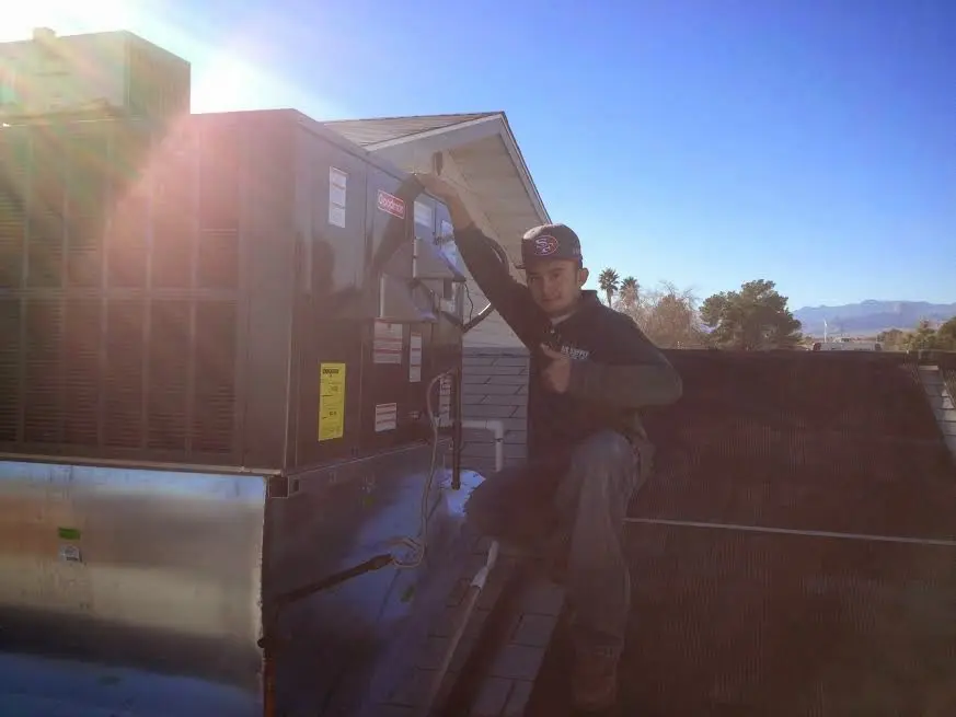 HVAC technician performing Air Duct Cleaning on a rooftop unit in Mahwah
