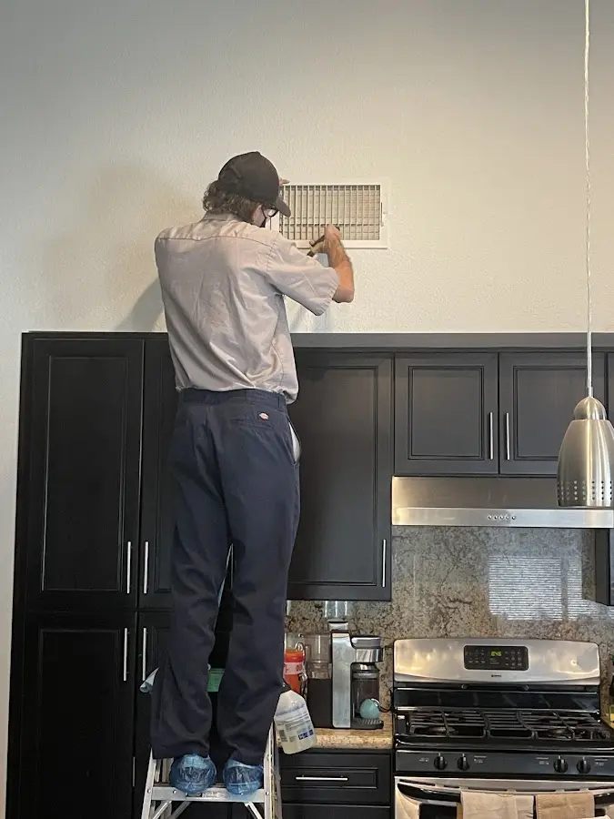 Technician inspecting an air vent during HVAC service in Mahwah